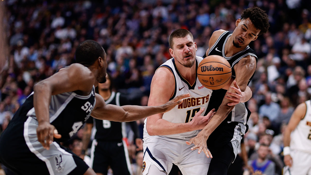 Denver Nuggets center Nikola Jokic (15) battles for a loose ball with San Antonio Spurs center Victor Wembanyama (1) and forward Harrison Barnes (40) in the third quarter at Ball Arena.