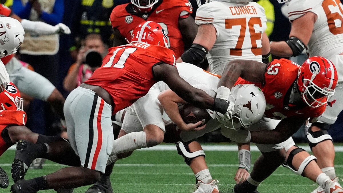 Georgia linebacker Jalon Walker (11) and Georgia defensive lineman Mykel Williams (13) take down Texas quarterback Quinn Ewers (3) during the second half of the SEC championship game against Texas in Atlanta, on Saturday, Dec. 7, 2024.