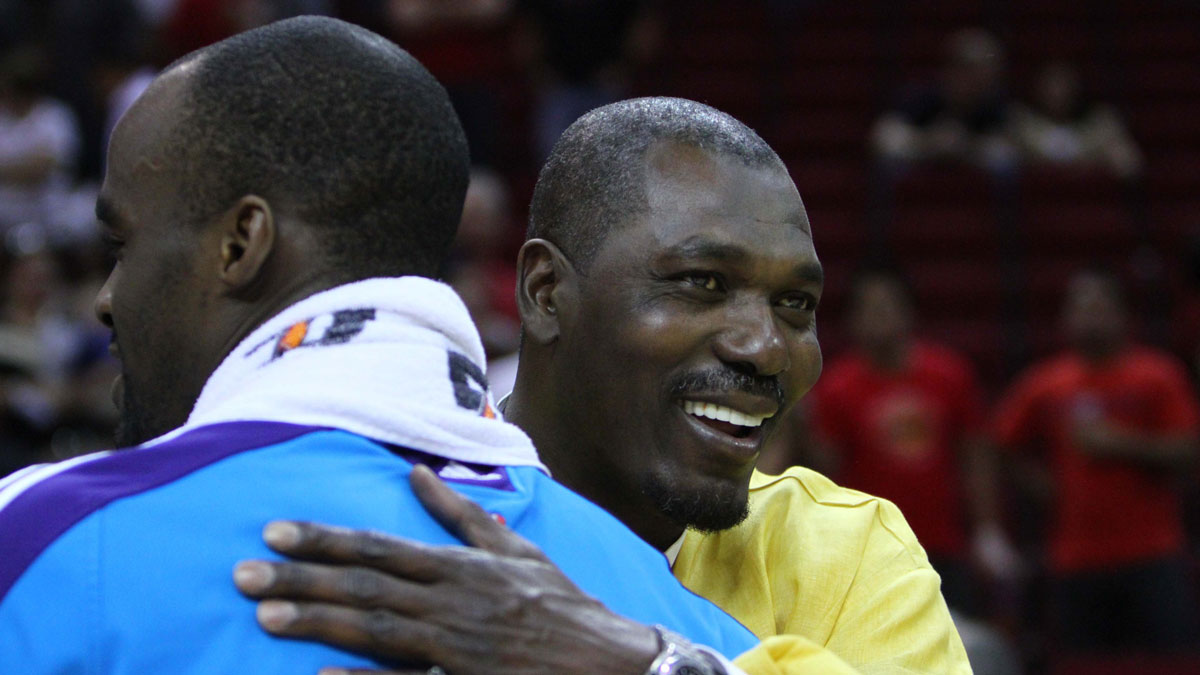 The new Orleans Hornets Center Emeka Okafor (50) hugs basketball hall Fame Center Hakeem Olajuvon (right) after play on Houston rockets in the toiotin center. Hornets won 123-115.