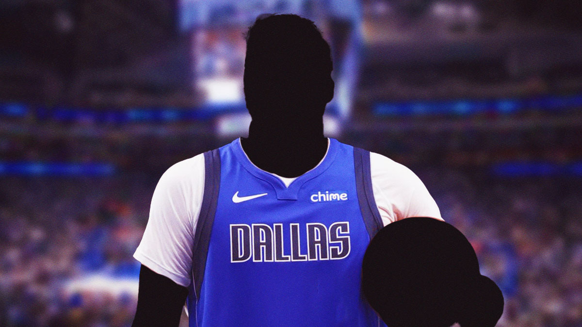 A shadowy player in a Dallas Mavericks jersey with the Mavericks arena in the background, two-way contract roster