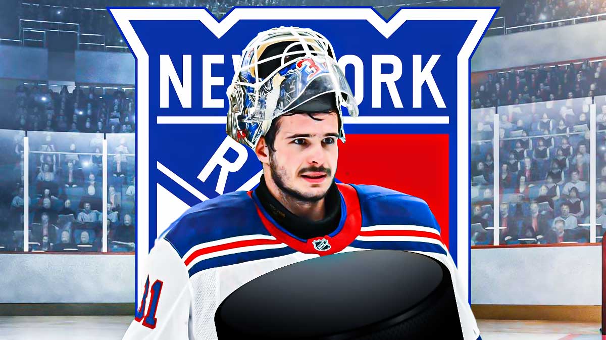 New York Rangers goalie Igor Shesterkin smiling, with a background of the Rangers logo behind him.