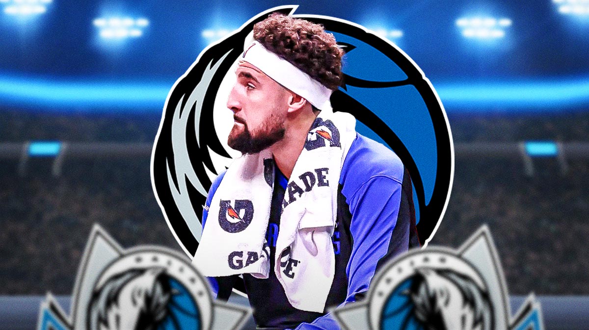 Mavericks Klay Thompson sitting on an NBA sideline looking serious.