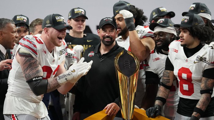 Ohio State Buckeyes defensive end Jack Sawyer (33) and Ohio State Buckeyes head coach Ryan Day celebrate on the podium after defeating the Notre Dame Fighting Irish in the CFP National Championship college football game at Mercedes-Benz Stadium
