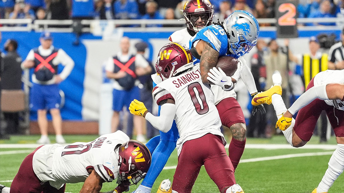 Detroit Lions running back Jahmyr Gibbs (26) runs for a touchdown against Washington Commanders cornerback Mike Sainristil (0) during the second half of the NFC divisional round at Ford Field in Detroit on Saturday, Jan. 18, 2025.