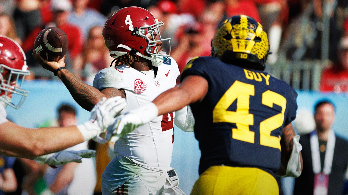 Alabama Crimson Tide quarterback Jalen Milroe (4) throws under pressure from Michigan Wolverines defensive end TJ Guy (42) during the second half at Raymond James Stadium.