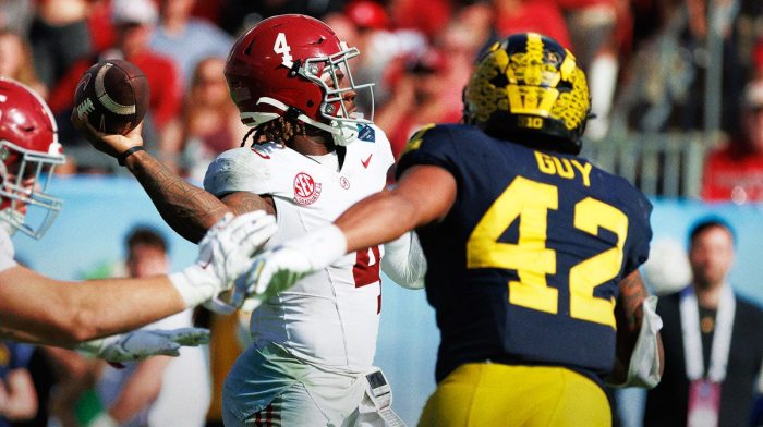 Alabama Crimson Tide quarterback Jalen Milroe (4) throws under pressure from Michigan Wolverines defensive end TJ Guy (42) during the second half at Raymond James Stadium.