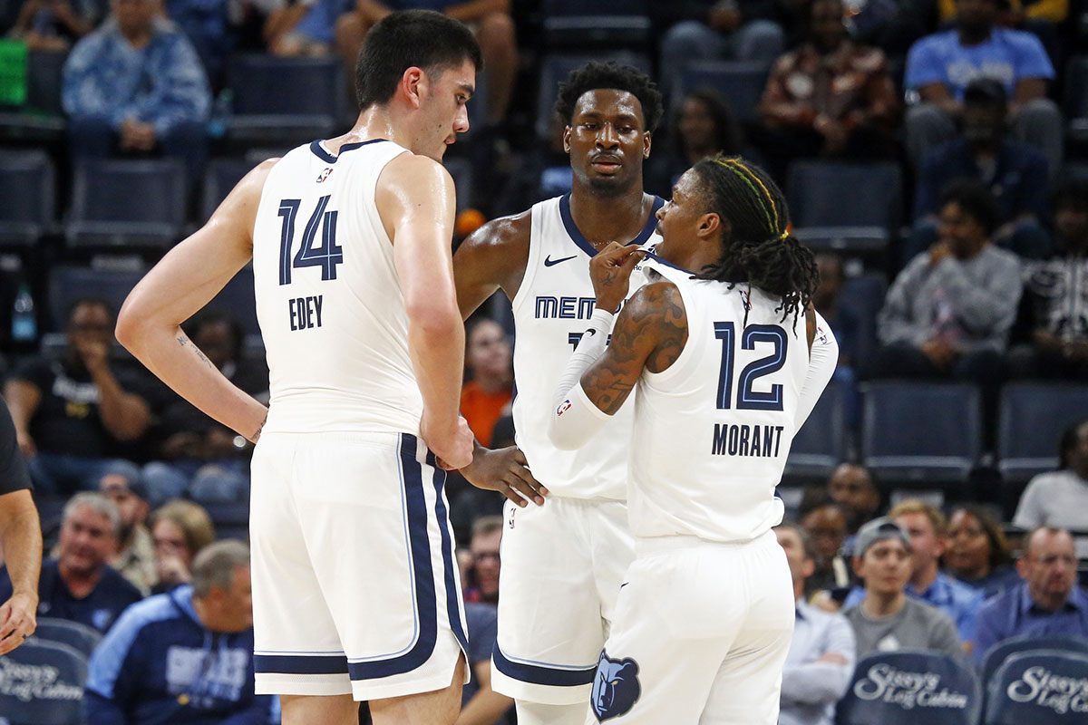 Memphis Grizzlies guard Ja Morant (12) talks with center Zach Edey (14) and forward Jaren Jackson Jr. (13) during the first half against the Brooklyn Nets at FedExForum.