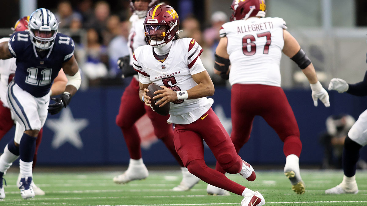 January 5, 2025; Arlington, Texas, USA; Washington Commanders quarterback Jayden Daniels (5) runs the ball against the Dallas Cowboys during the second quarter at AT&T Stadium. 