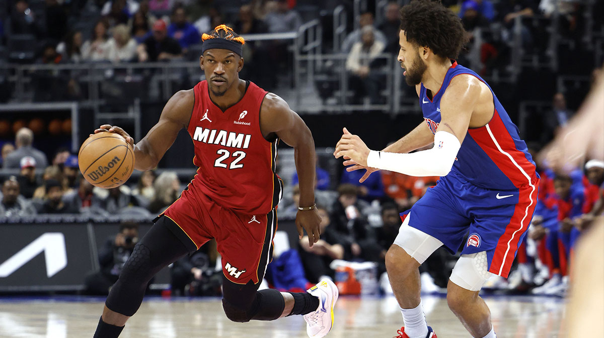 Miami Heat forward Jimmy Butler (22) dribbles as Detroit Pistons guard Cade Cunningham (2) defends in the first half at Little Caesars Arena. 