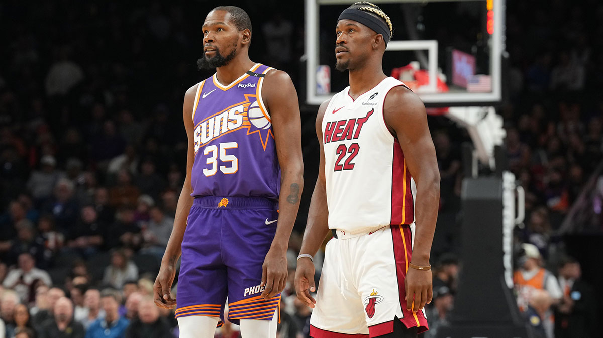 Phoenix Suns forward Kevin Durant (35) and Miami Heat forward Jimmy Butler (22) look on during the first half at Footprint Center.