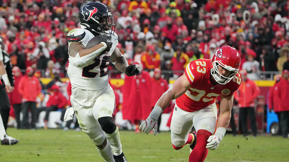 Houston Texans running back Joe Mixon (28) runs the ball in for a touchdown against Kansas City Chiefs linebacker Drue Tranquill (23) during the third quarter of a 2025 AFC divisional round game at GEHA Field at Arrowhead Stadium. 