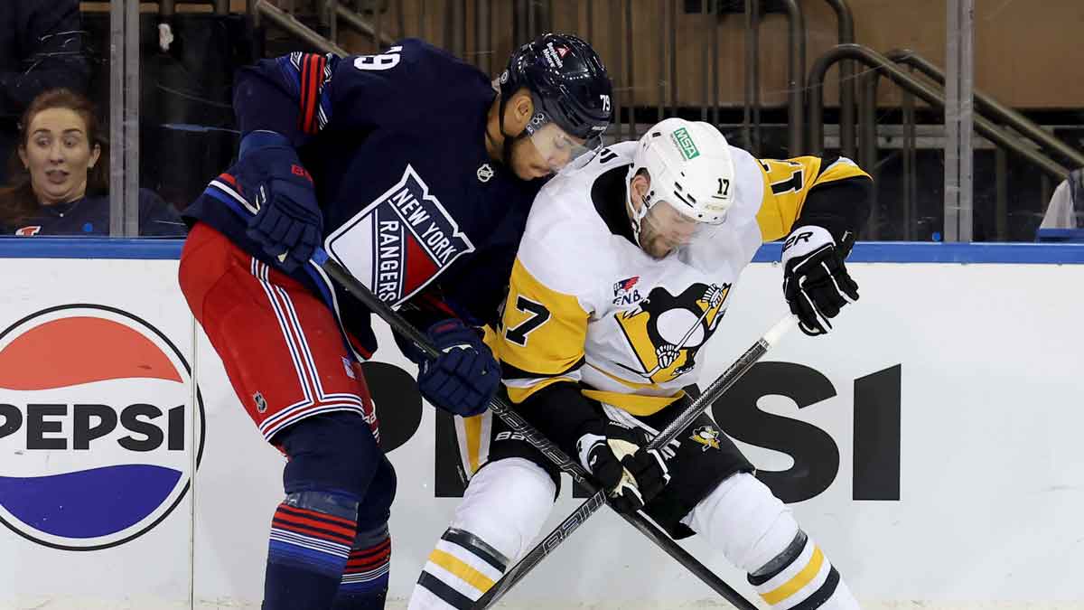 New York Rangers defenseman K'Andre Miller (79) and Pittsburgh Penguins right wing Bryan Rust (17) fight for the puck during the third period at Madison Square Garden.
