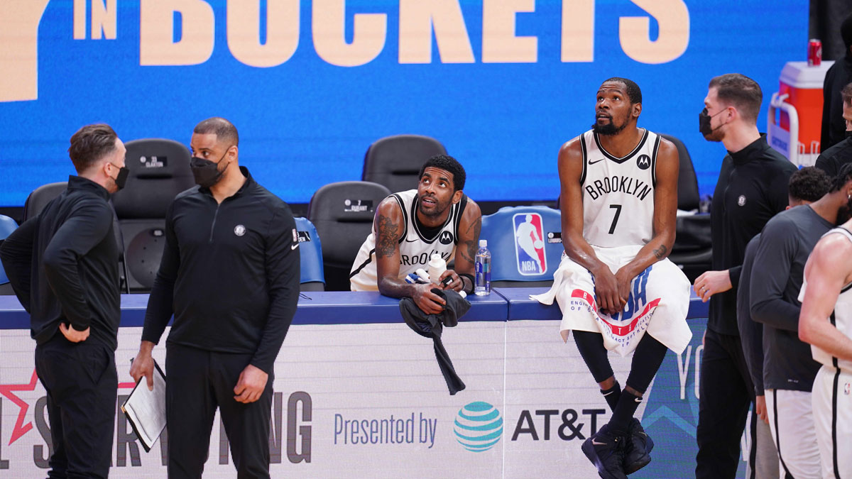 Brooklyn Nets Guard Kirie Irving (11) and Near Kevin Durant (7) Rest near the team benches over time against Golden State Warriors in the fourth quarter of Chese CENTER. 