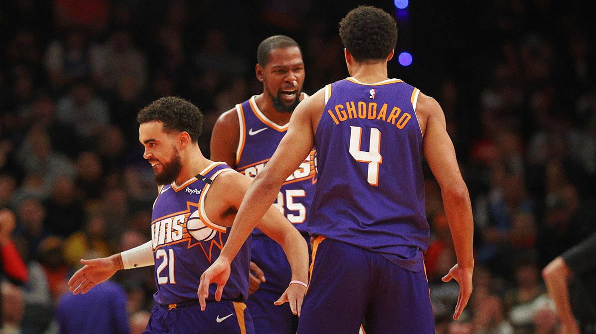 Phoenix Suns guard Tyus Jones (21) celebrates with forward Kevin Durant (35) and center Oso Ighodaro (4) against the Atlanta Hawks in the second half at Footprint Center.