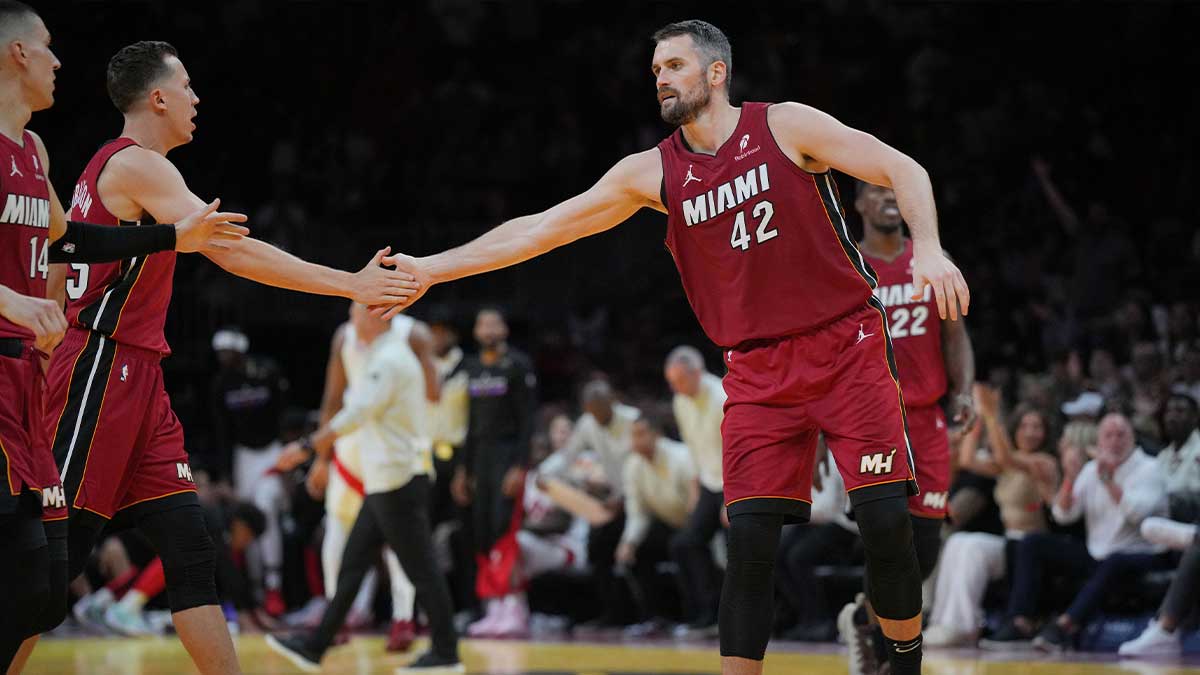 Miami Heat forward Kevin Love (42) is congratulated by forward Duncan Robinson (55) after hitting a three-pointer against the Toronto Raptors in the first half in an NBA Cup game at Kaseya Center.