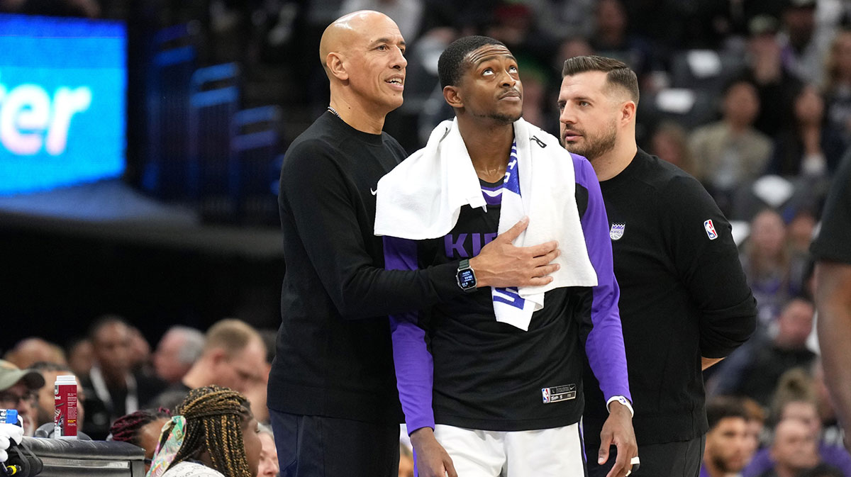 Kings guard De'Aaron Fox (center) stands on the sideline with interim head coach Doug Christie (left) and assistant coach Luke Loucks (right) during the fourth quarter against the Dallas Mavericks at Golden 1 Center
