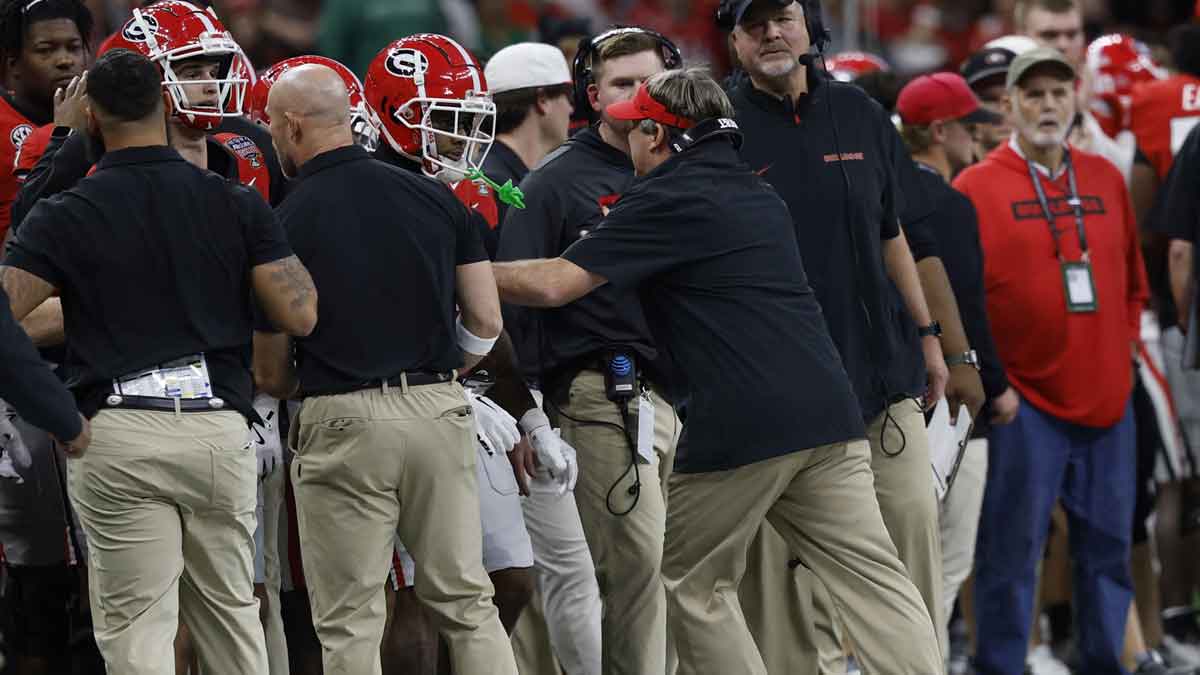 Jan 2, 2025; New Orleans, LA, USA; Georgia Bulldogs head coach Kirby Smart (R) pushes his players a coaches away from the sidelines after the Bulldogs were called for sideline interference against the Notre Dame Fighting Irish during the second quarter at Caesars Superdome.