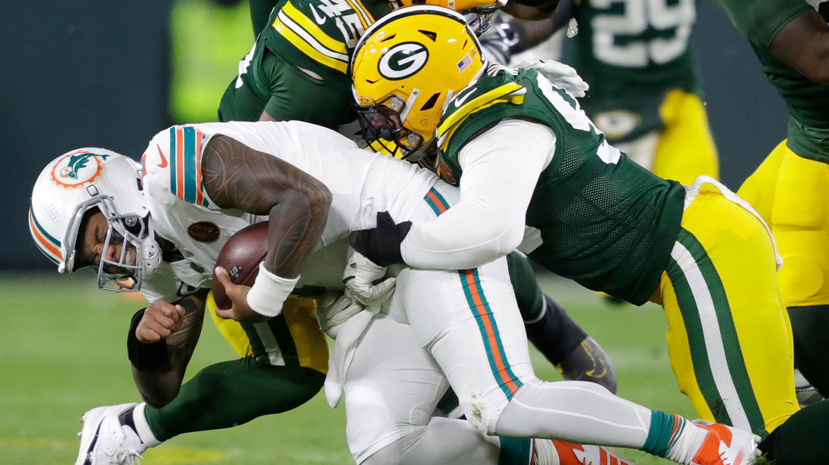 Miami Dolphins quarterback Tua Tagovailoa (1) is sacked by Green Bay Packers defensive end Lukas Van Ness (90) during their football game Thursday, November 28, 2024, at Lambeau Field in Green Bay, Wisconsin.