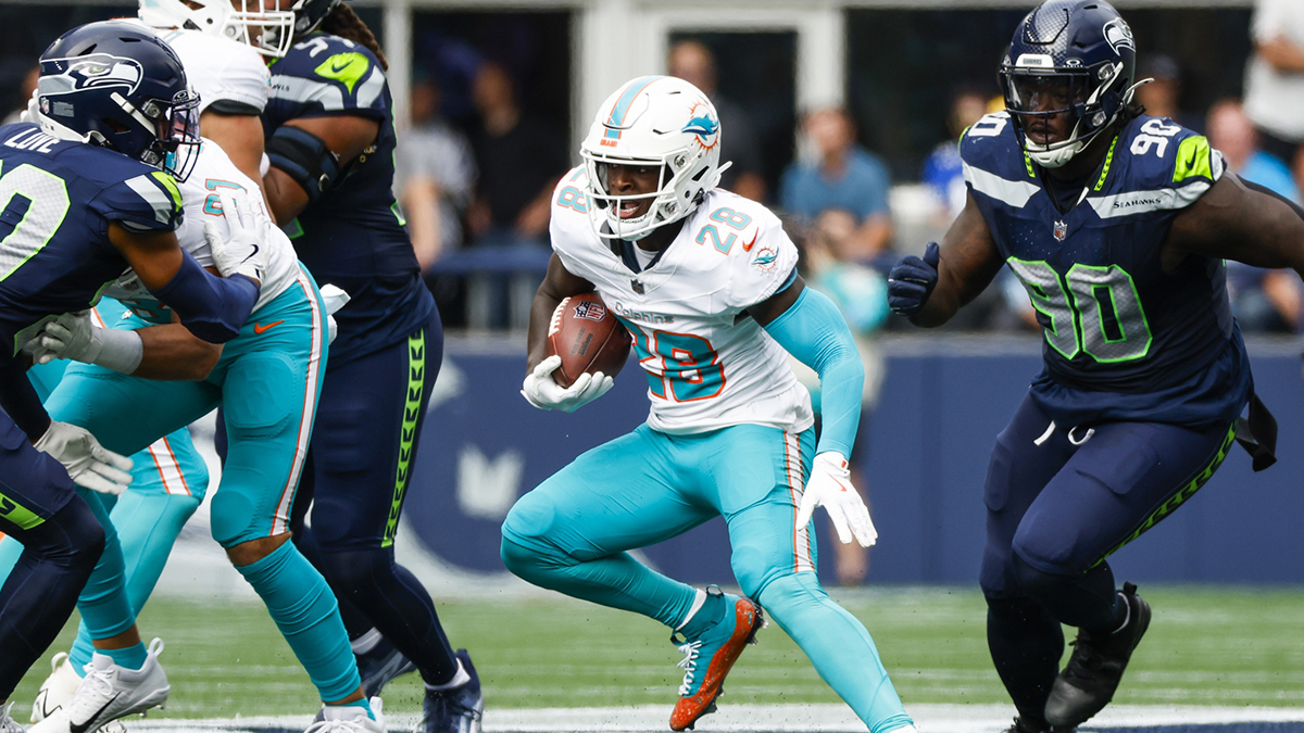 Miami Dolphins running back DeVon Achane (28) rushes ahead of Seattle Seahawks defensive tackle Jarran Reed (90) during the second quarter at Lumen Field.