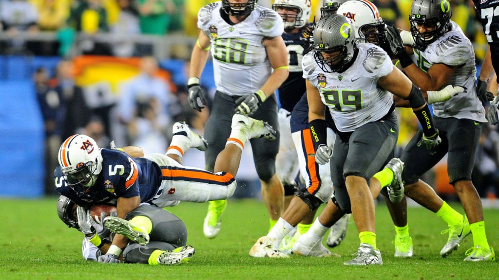 Auburn Tigers running back Michael Dyer (5) uses his hand to stay off the grass as Oregon Ducks defender Eddie Pleasant attempts to tackle him during the fourth quarter of the 2011 BCS National Championship game at University of Phoenix Stadium.