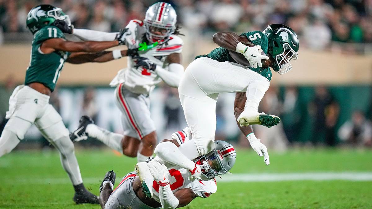 Sep 28, 2024; East Lansing, Michigan, USA; Ohio State Buckeyes safety Caleb Downs (2) tackles Michigan State Spartans running back Nate Carter (5) in the first half at Spartan Stadium on Saturday.