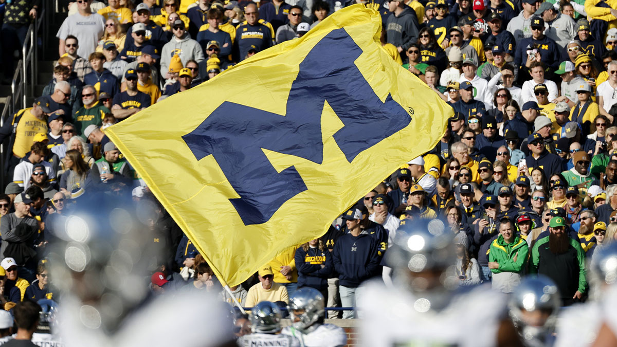 Michigan Wolverines cheerleader runs with a flag before the game against the Oregon Ducks at Michigan Stadium.