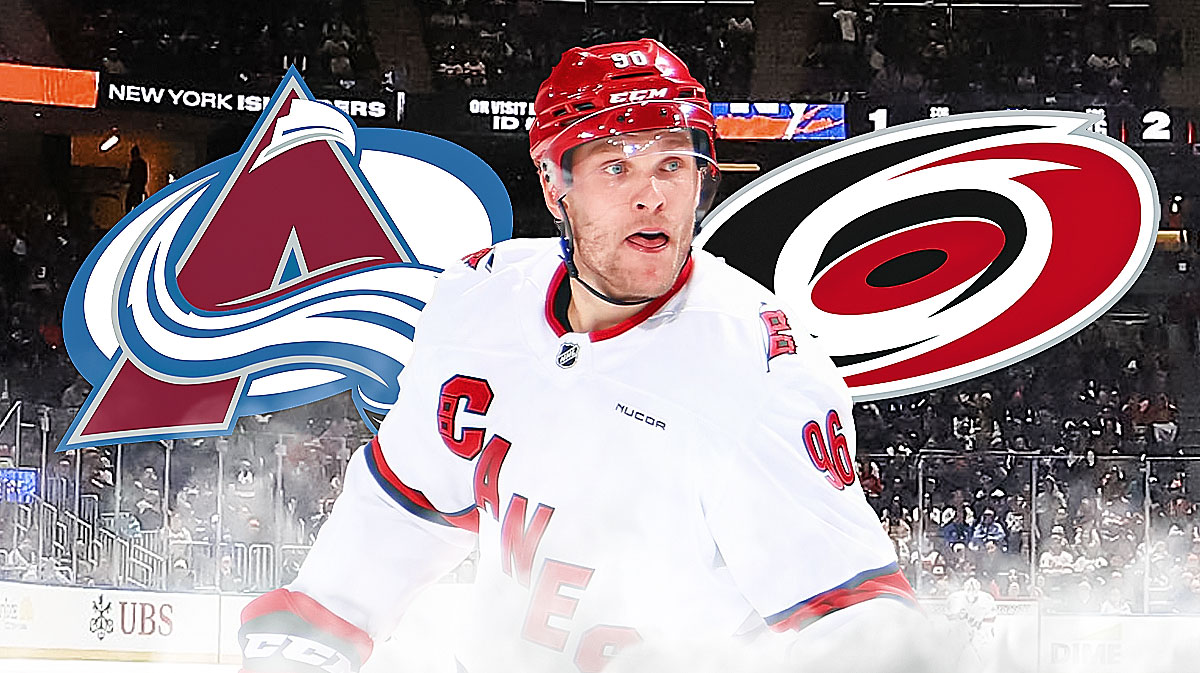 Mikko Rantanen in with Hurricanes logo behind him to right. Avalanche behind him to left