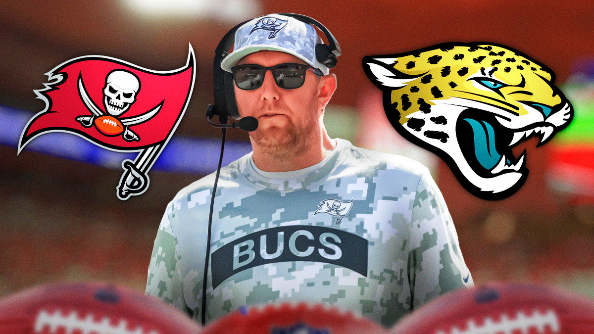 Head coach Liam Coen between the logos of the Tampa Bay Buccaneers and Jacksonville Jaguars