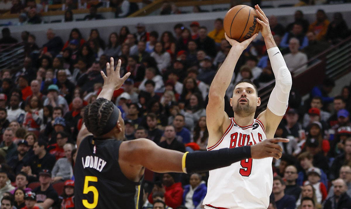 Chicago Bulls center Nikola Vucevic (9) shoots against Golden State Warriors forward Kevon Looney (5) during the second half of an NBA game at United Center.