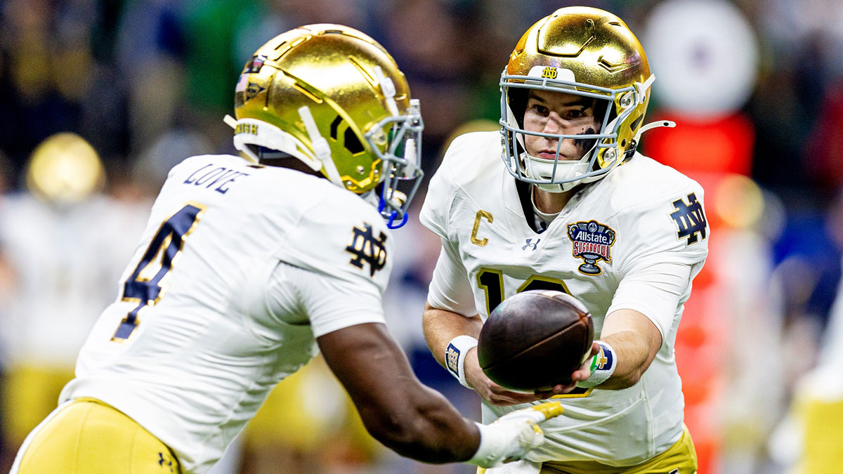 Notre Dame Fighting Irish running back Jeremiiah Love (4) hands the ball off to Notre Dame Fighting Irish quarterback Riley Leonard (13) during the first quarter at Caesars Superdome.