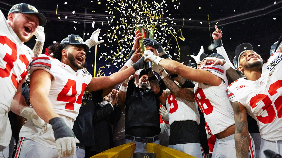 Ohio State Buckeyes head coach Ryan Day hoists the trophy as he celebrates with his players after defeating the Notre Dame Fighting Irish during the CFP National Championship college football game at Mercedes-Benz Stadium.