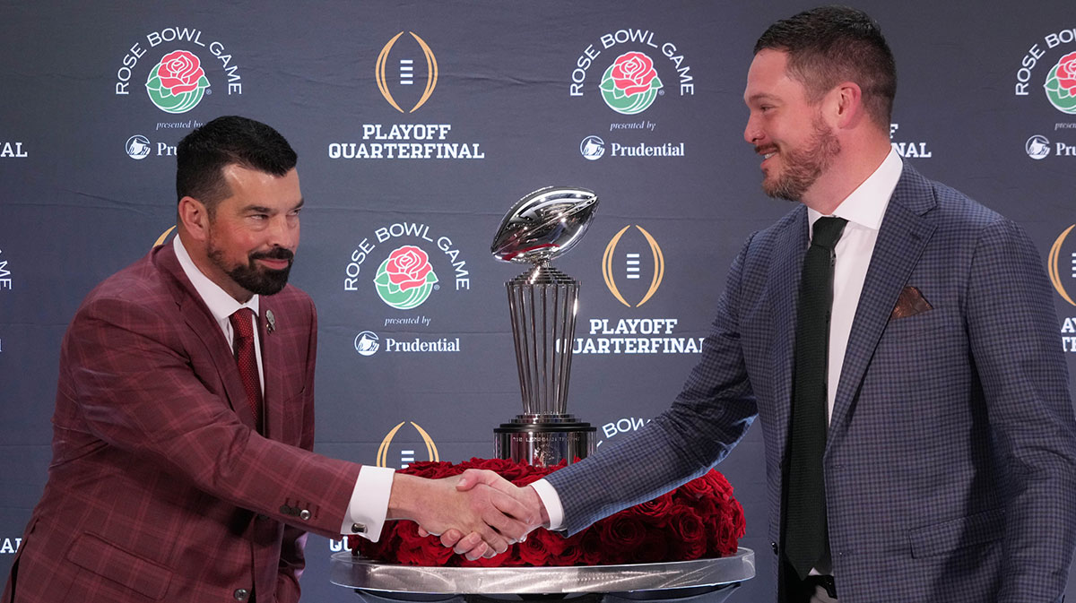 Ohio State Buckeyes head coach Ryan Day (left) and Oregon Ducks head coach Dan Lanning shake hands with the Leishman Trophy as a backdrop during the Rose Bowl head coaches press conference at Sheraton Grand LA.