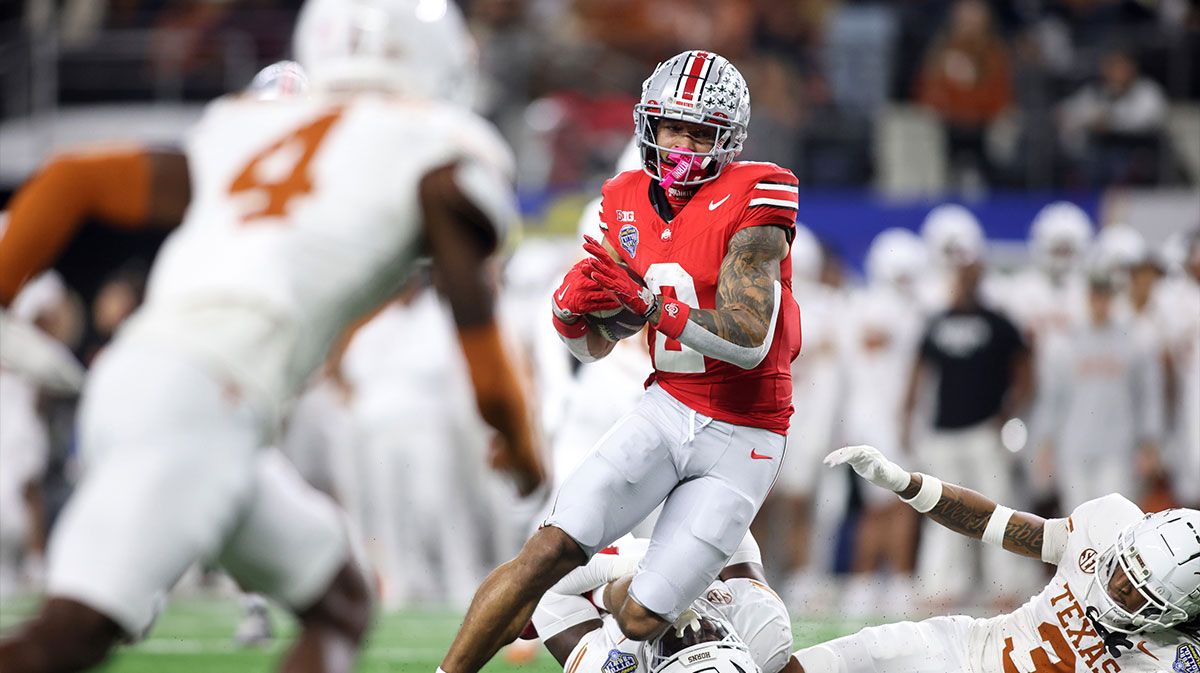 Ohio State Buckeyes wide receiver Emeka Egbuka (2) runs against Texas Longhorns defensive back Jaylon Guilbeau (3) during the first quarter of the College Football Playoff semifinal in the Cotton Bowl at AT&T Stadium. 