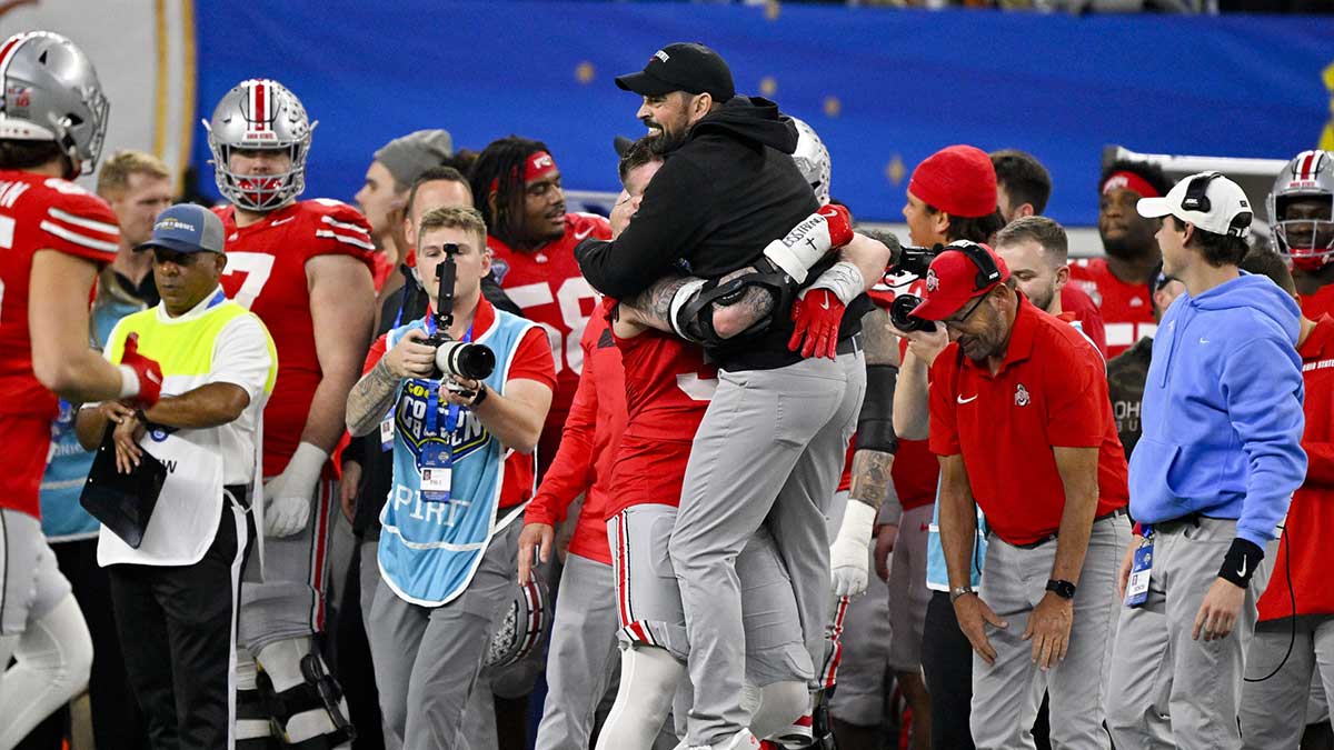 Ohio State Buckeyes defensive end Jack Sawyer (33) hugs head coach Ryan Day during the game against the Texas Longhorns at AT&T Stadium. 