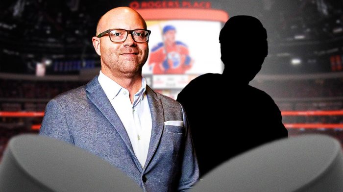 Oilers GM Stan Bowman and a blank silhouette of a hockey player inside Rogers Place in Edmonton