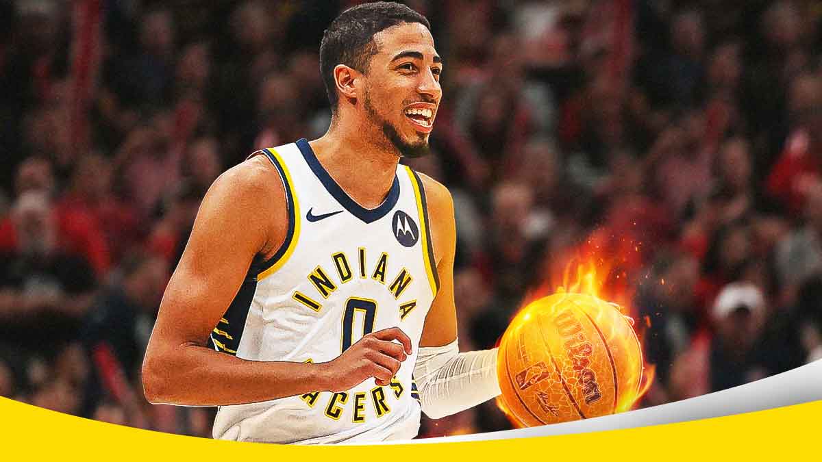 Pacers' Tyrese Haliburton smiling while holding a ball on fire