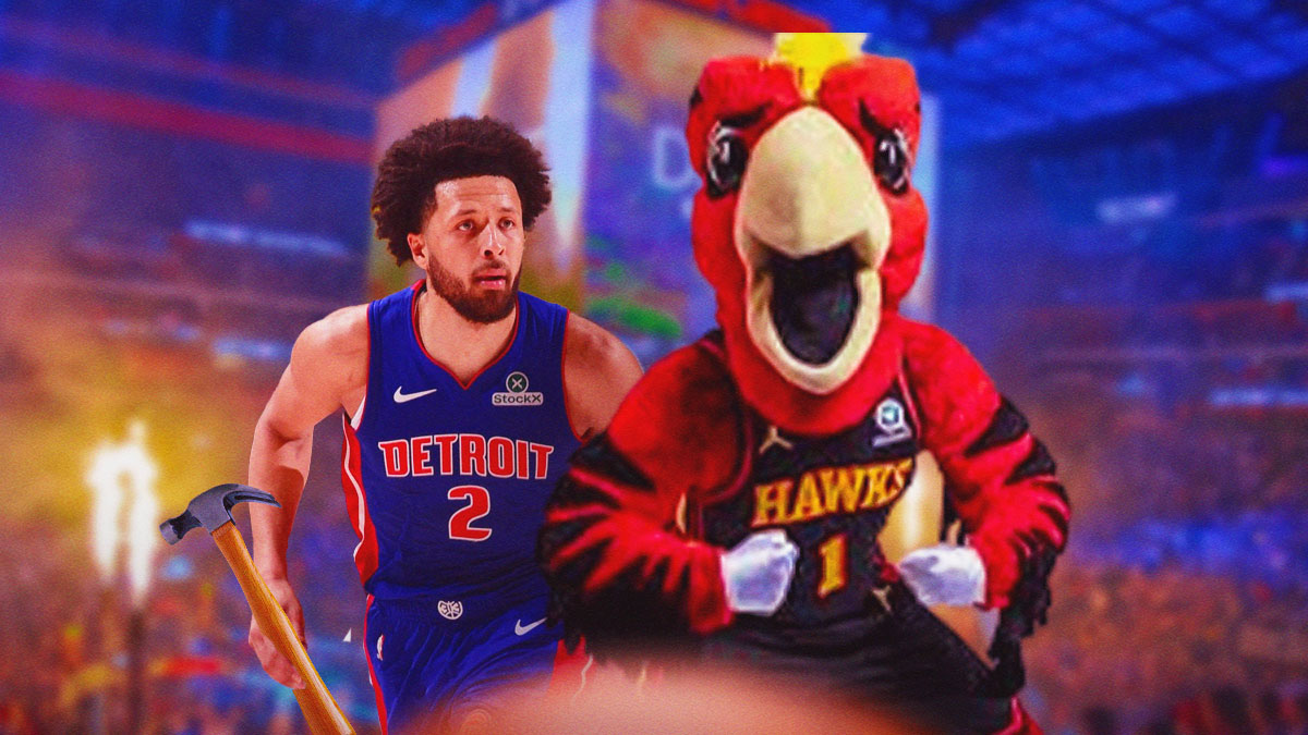 Cade Cunningham holding a hammer next to the Hawks mascot on a Pistons basketball court.