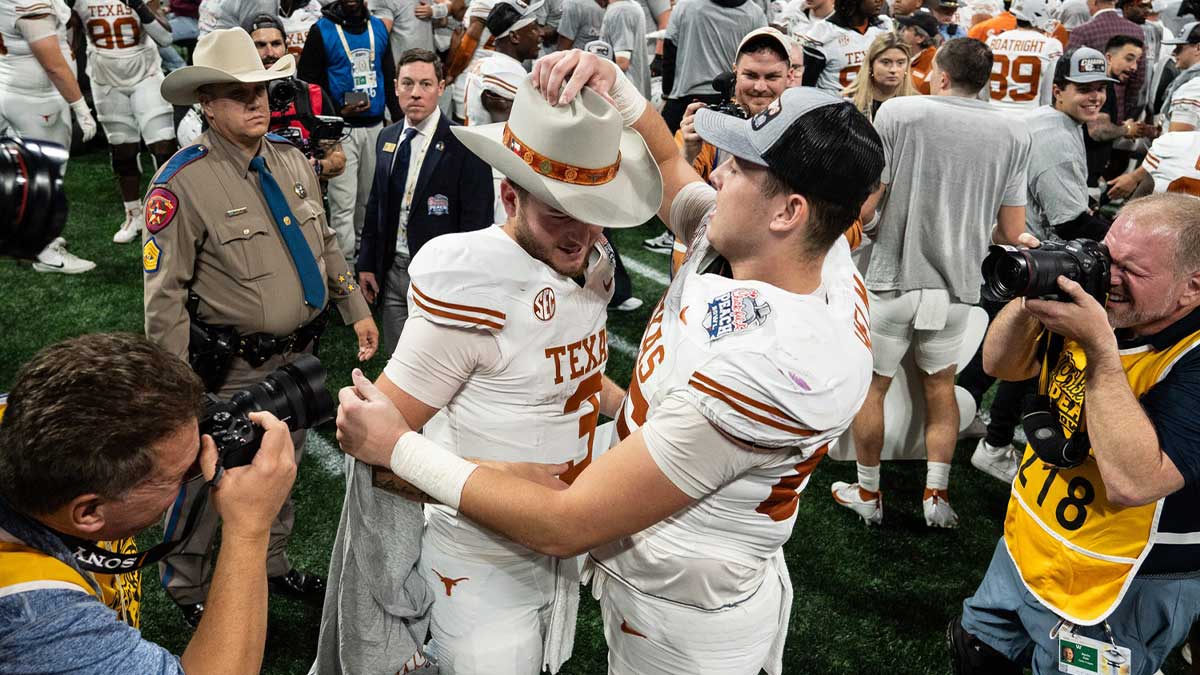 Texas Longhorns tight end Gunnar Helm (85) gives Texas Longhorns quarterback Quinn Ewers (3) a hat as they celebrate their win in the Peach Bowl College Football Playoff quarterfinal against Arizona State at Mercedes-Benz Stadium in Atlanta, Georgia, Jan. 1, 2025.