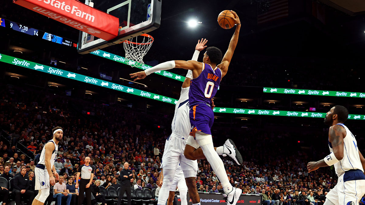 Phoenix Suns forward Ryan Dunn (0) dunks the ball against Dallas Mavericks guard Kyrie Irving (11) during the first quarter at Footprint Center.