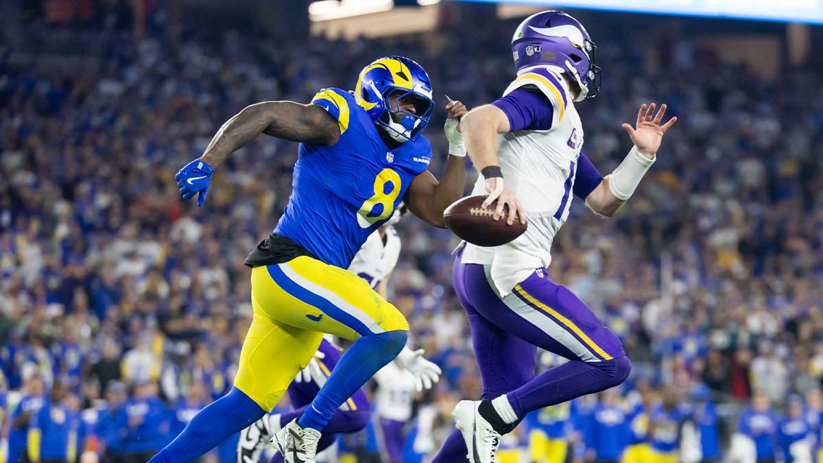 January 13, 2025; Glendale, AZ, USA; Minnesota Vikings quarterback Sam Darnold (14) is chased by Los Angeles Rams tight end Jared Vers (8) during the NFC wild card game at State Farm Stadium.