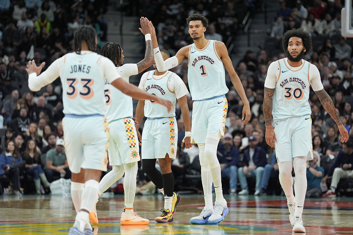 San Antonio Spurs center Victor Wembanyama (1) celebrates with San Antonio Spurs guard Stephon Castle (5) and other teammates in the first half against the Atlanta Hawks at Frost Bank Center.