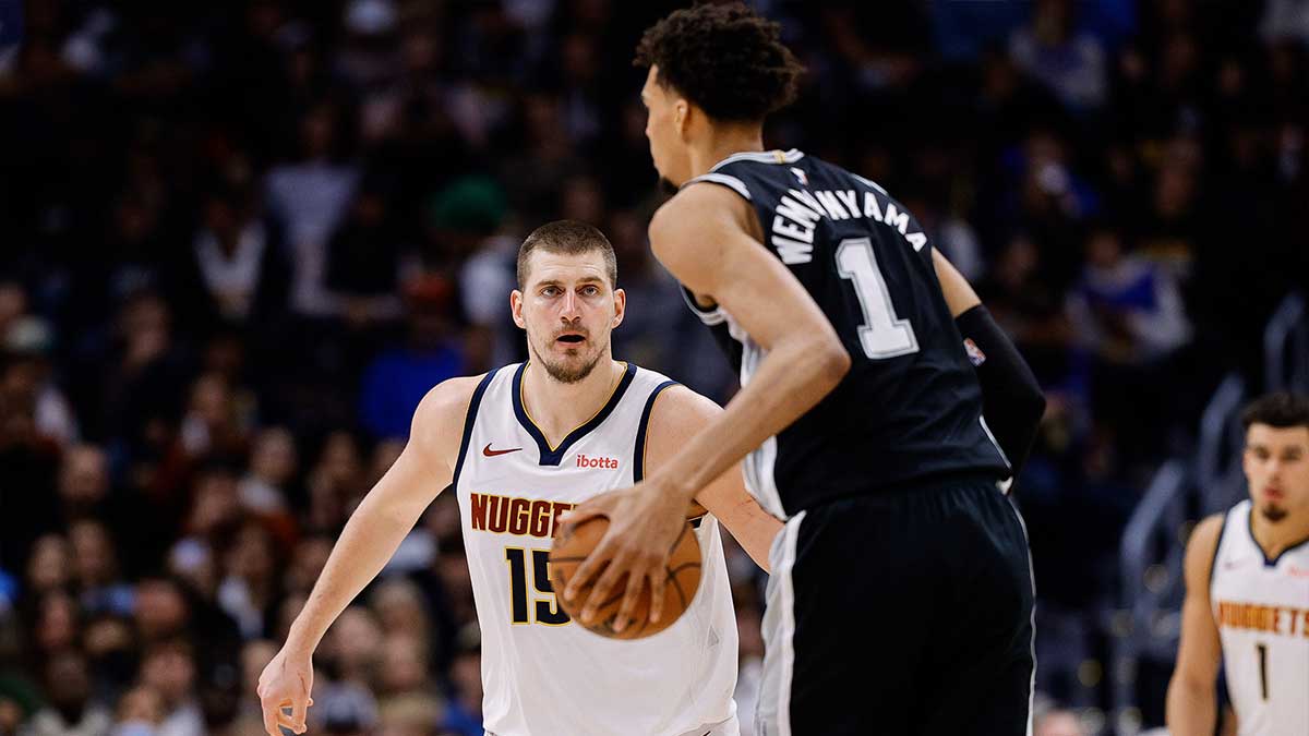 San Antonio Spurs center Victor Wembanyama (1) controls the ball as Denver Nuggets center Nikola Jokic (15) guards in the third quarter at Ball Arena.