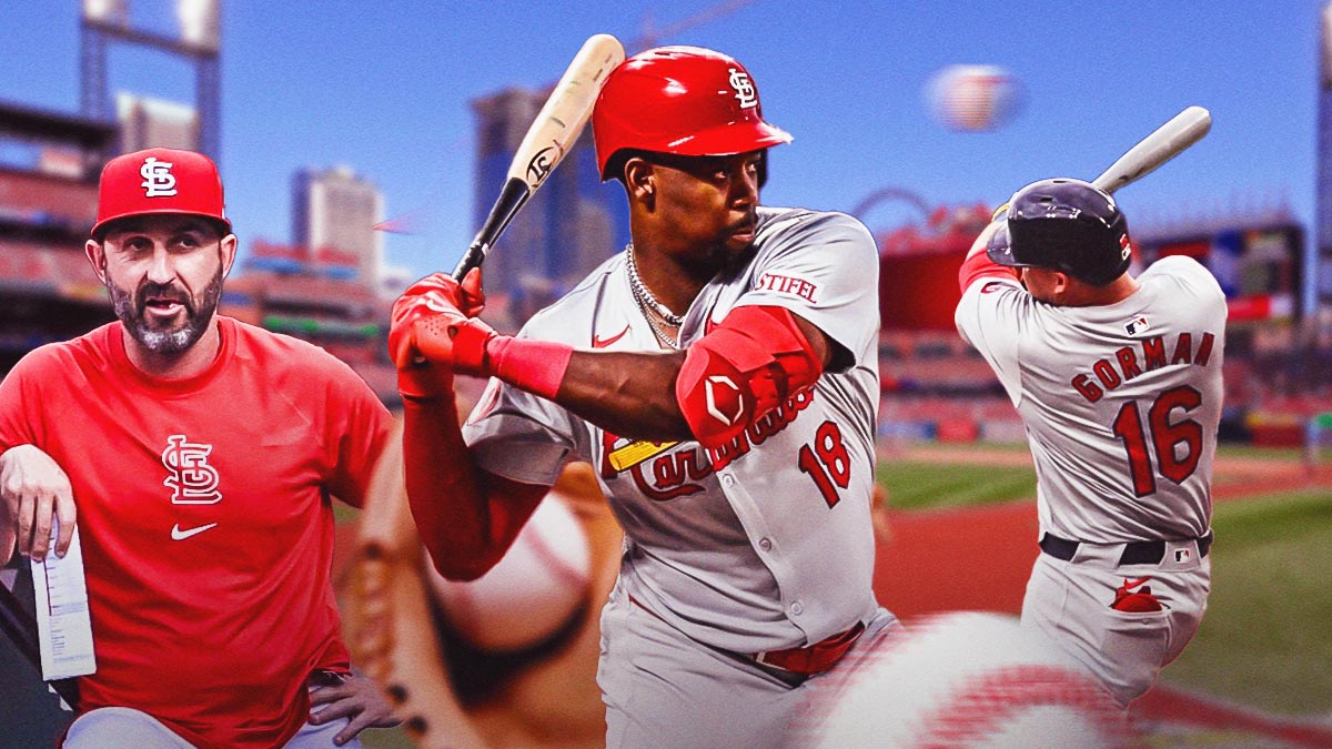 St. Louis Cardinals outfielder Jordan Walker swinging a bat in center, St. Louis Cardinals infielder Nolan Gorman swinging a bat on right side, St. Louis Cardinals bench coach Daniel Descalso on left side, Busch Stadium (home stadium of the St. Louis Cardinals) in background