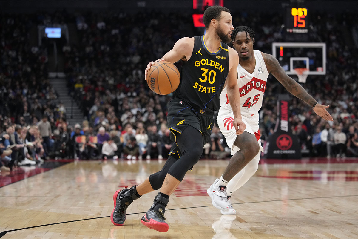 Golden State Warriors guard Stephen Curry (30) dribbles past Toronto Raptors guard Davion Mitchell (45) during the second half at Scotiabank Arena.