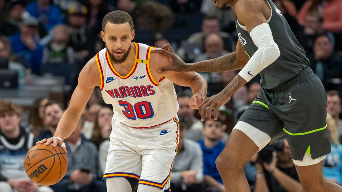 Golden State Warriors guard Stephen Curry (30) dribbles past Minnesota Timberwolves forward Jaden McDaniels (3) in the second half at Target Center.