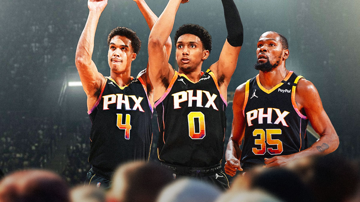 Suns rookies Oso Ighodaro and Ryan Dunn smiling, with their hands up to the crowd. Beside them is Suns forward Kevin Durant, smiling and clapping his hands.