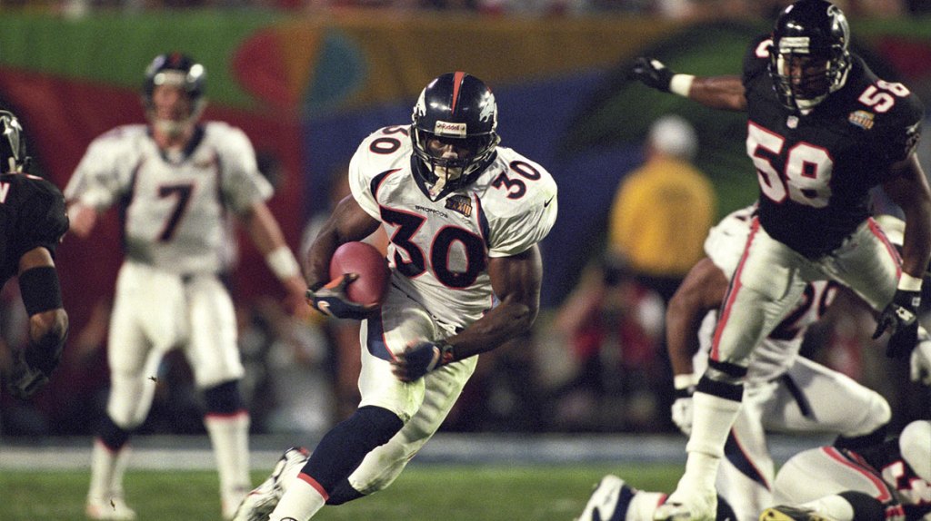 Denver Broncos running back Terrell Davis (30) carries the ball past Atlanta Falcons linebacker Jesse Tuggle (58) during Super Bowl XXXIII at Dolphin Stadium. The Broncos defeated the Falcons 31-19.