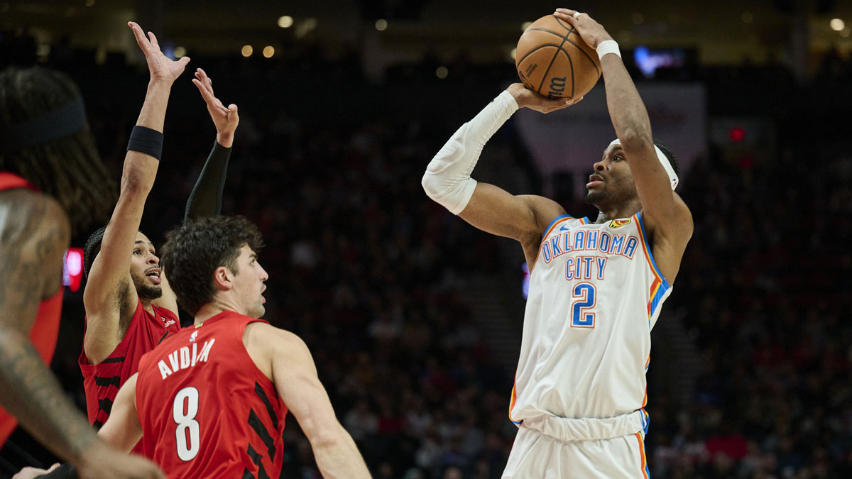     Thunder guard Shai Gilgeous-Alexander (2) makes a jump shot in the second half against Portland Trail Blazers forward Danny Avdia (8) and forward Toumani Kamara (33) at the Moda Center