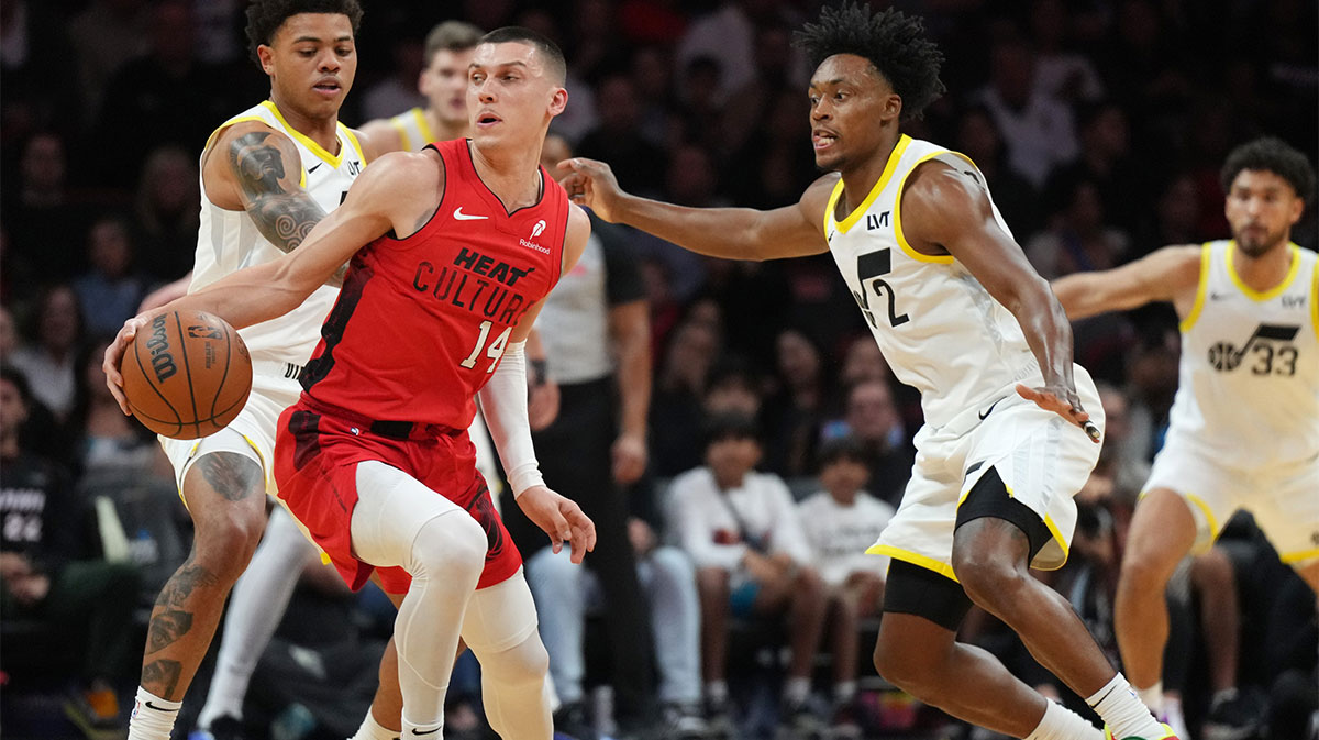 Miami Heat guard Tyler Herro (14) looks for space on the floor as Utah Jazz guard Collin Sexton (2) and guard Keyonte George (3) defend during the first half at Kaseya Center.