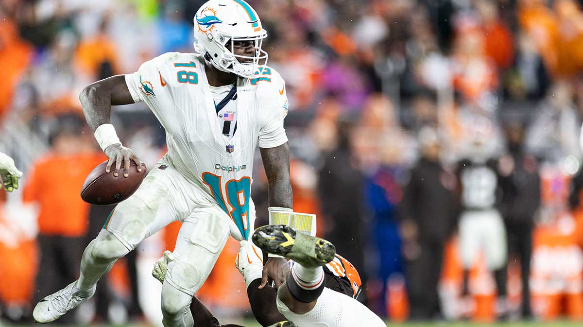 Miami Dolphins quarterback Tyler Huntley (18) tries to free himself from a tackle by Cleveland Browns defensive end Isaiah McGuire (57) during the fourth quarter at Huntington Bank Field.